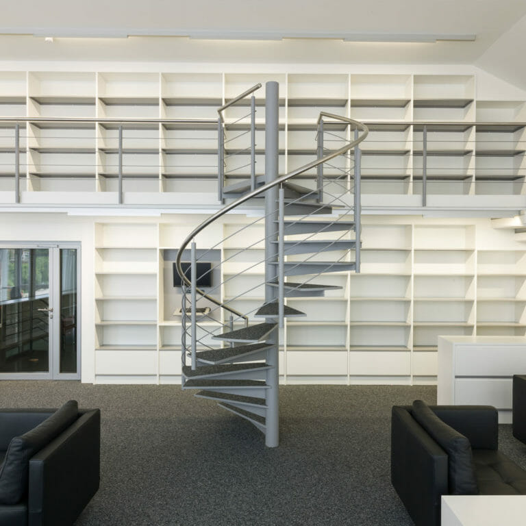 Bibliothek mit Bücherregalen auf zwei Ebenen mit Wendeltreppe