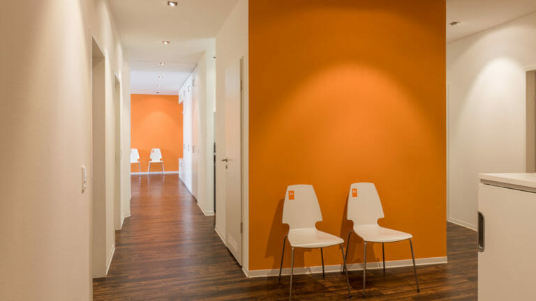 Wartebereich im Flur mit orange aktzentuierten Wänden