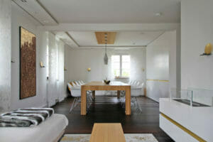 moderner Wohn und Esszimmerbereich, mit großem Eichenholztisch, weiß lackierten Designer Einbaumöbeln